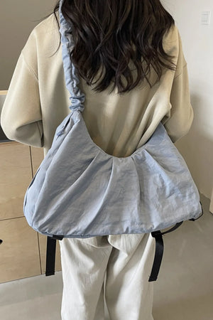 Light blue gathered crescent shoulder bag with ruched strap and pleated detail.