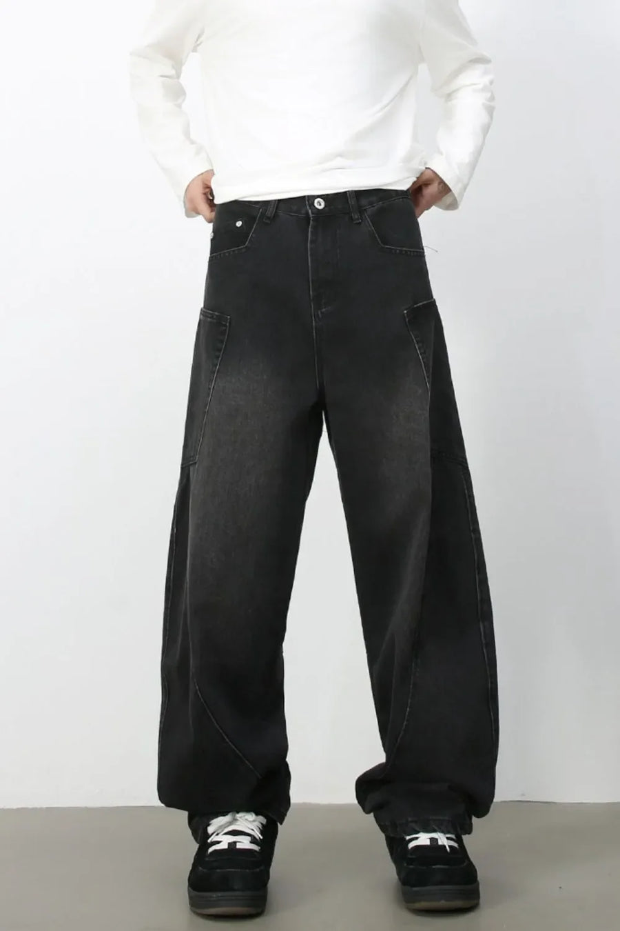 Black denim baggy trousers with a relaxed fit and unique pocket details.