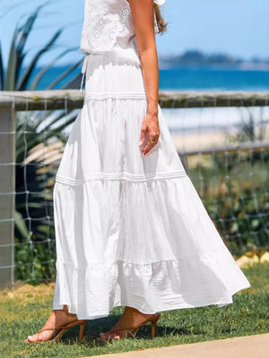 White tiered maxi skirt with delicate pleating and a flowing silhouette.