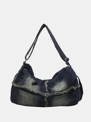 Dark wash denim slouch crossbody bag with frayed edges and adjustable strap.