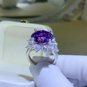 Amethyst sunburst moissanite cocktail ring with deep purple center stone and clear accent stones.