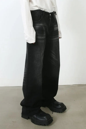 Dark wash denim barrel leg jeans with whiskering detail.