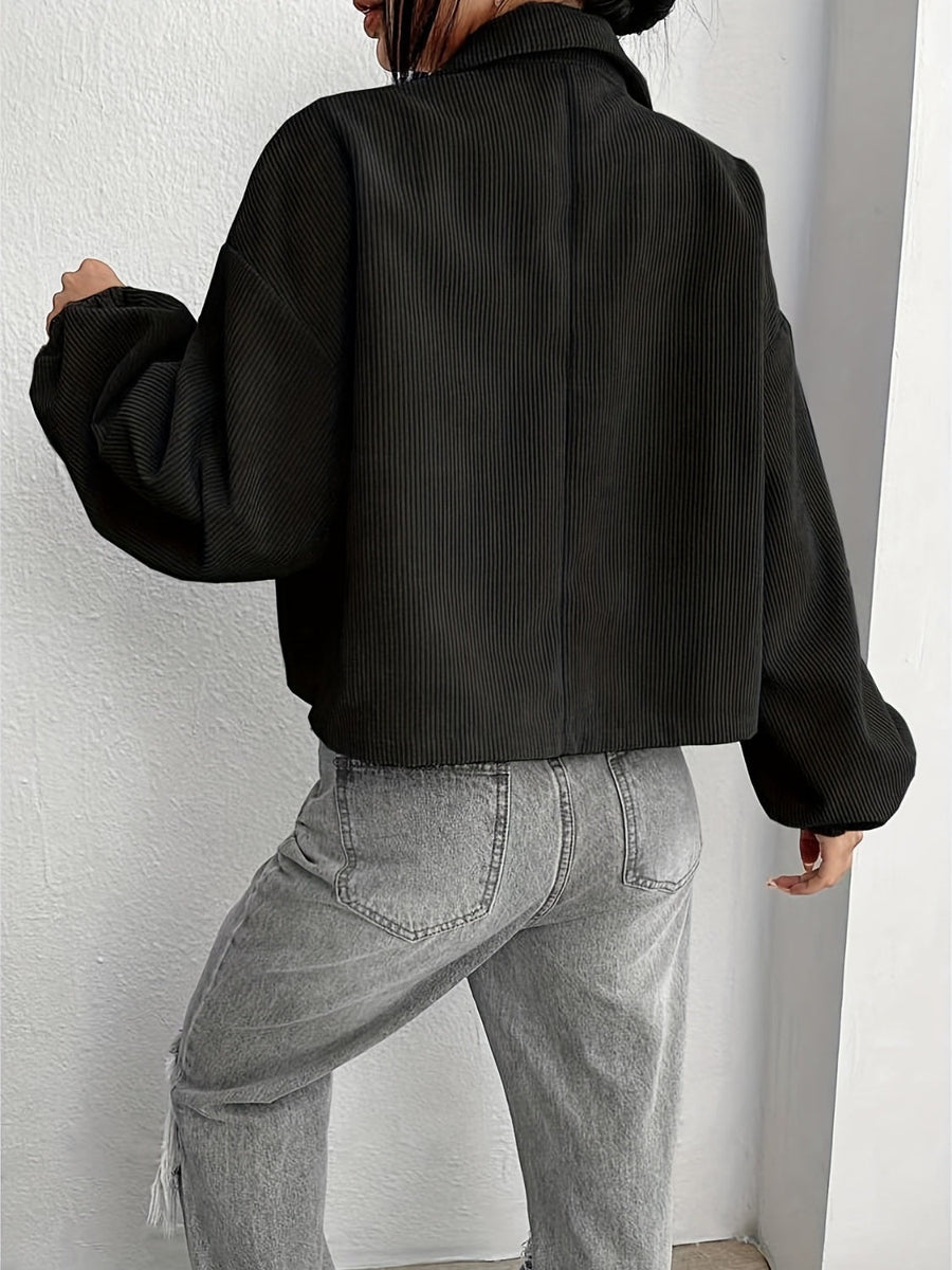 Black corduroy blouson jacket with balloon sleeves and collar, cropped length.