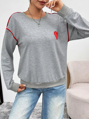 Gray sweatshirt with red heart embroidery and contrast piping detail.
