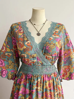 Floral lace-trimmed surplice maxi dress in teal with a vibrant floral print and boho style.