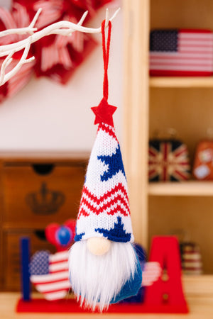 Patriotic knit gnome ornament with red, white, and blue striped hat and white beard.
