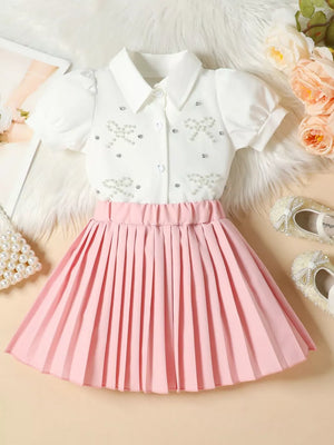 Girls' white bow-embellished top with puff sleeves and pink pleated skirt duo.