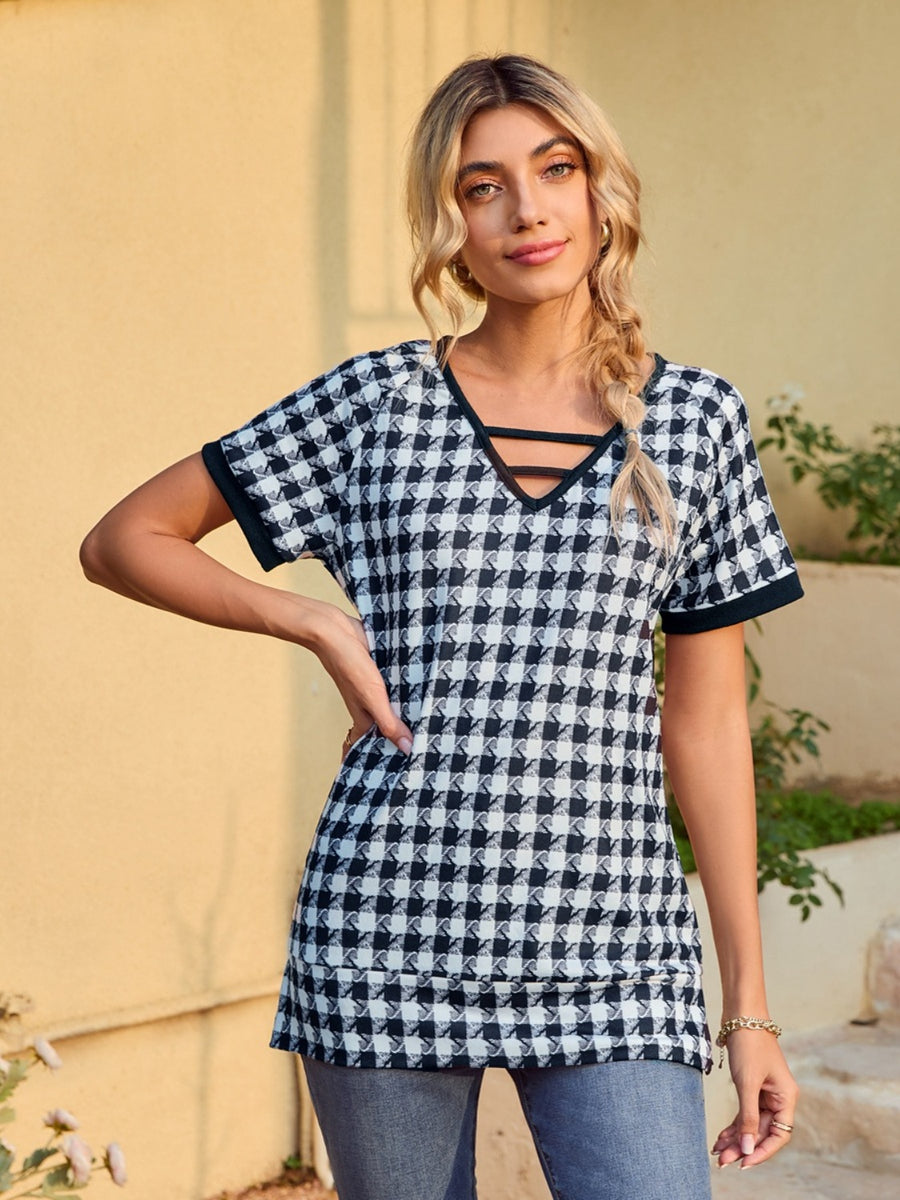 Houndstooth tunic top with cutout neckline and short sleeves.