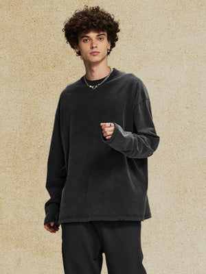 Oversized black washed cotton long sleeve t-shirt with distressed hem and crew neck.