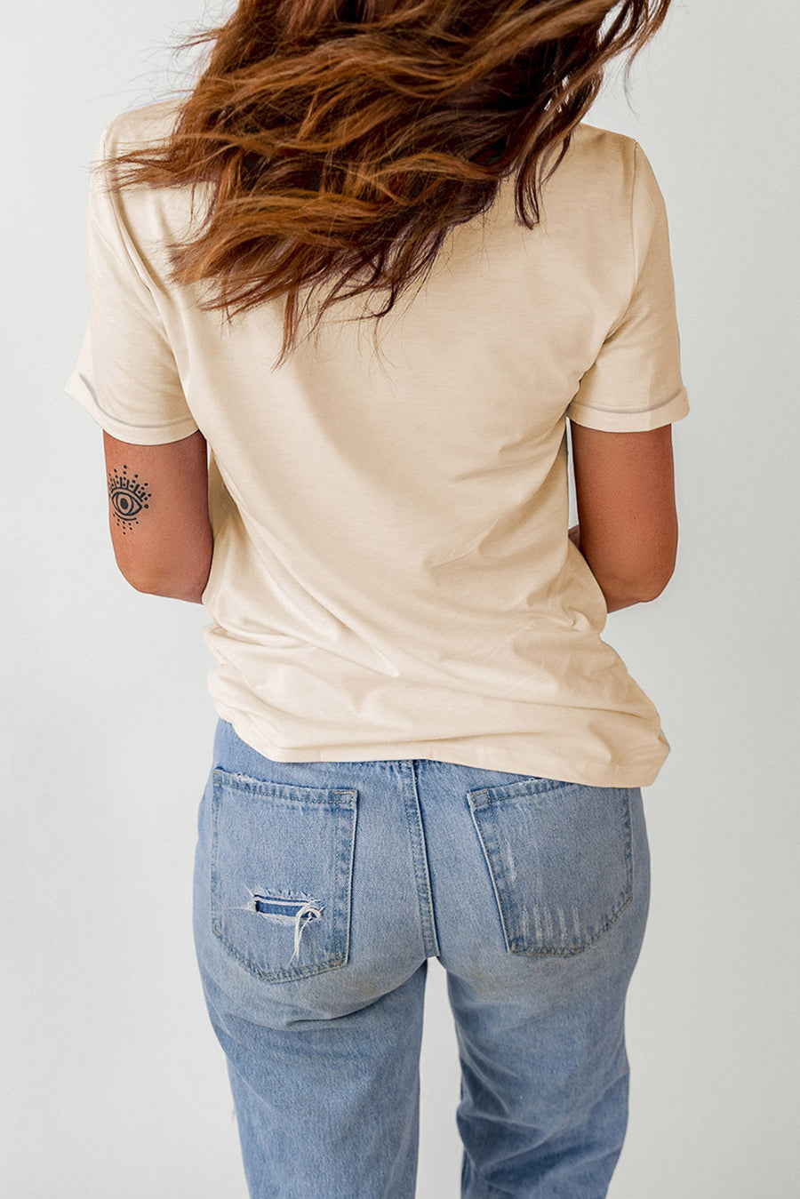 Cream t-shirt with short sleeves and a graphic detail on the arm.