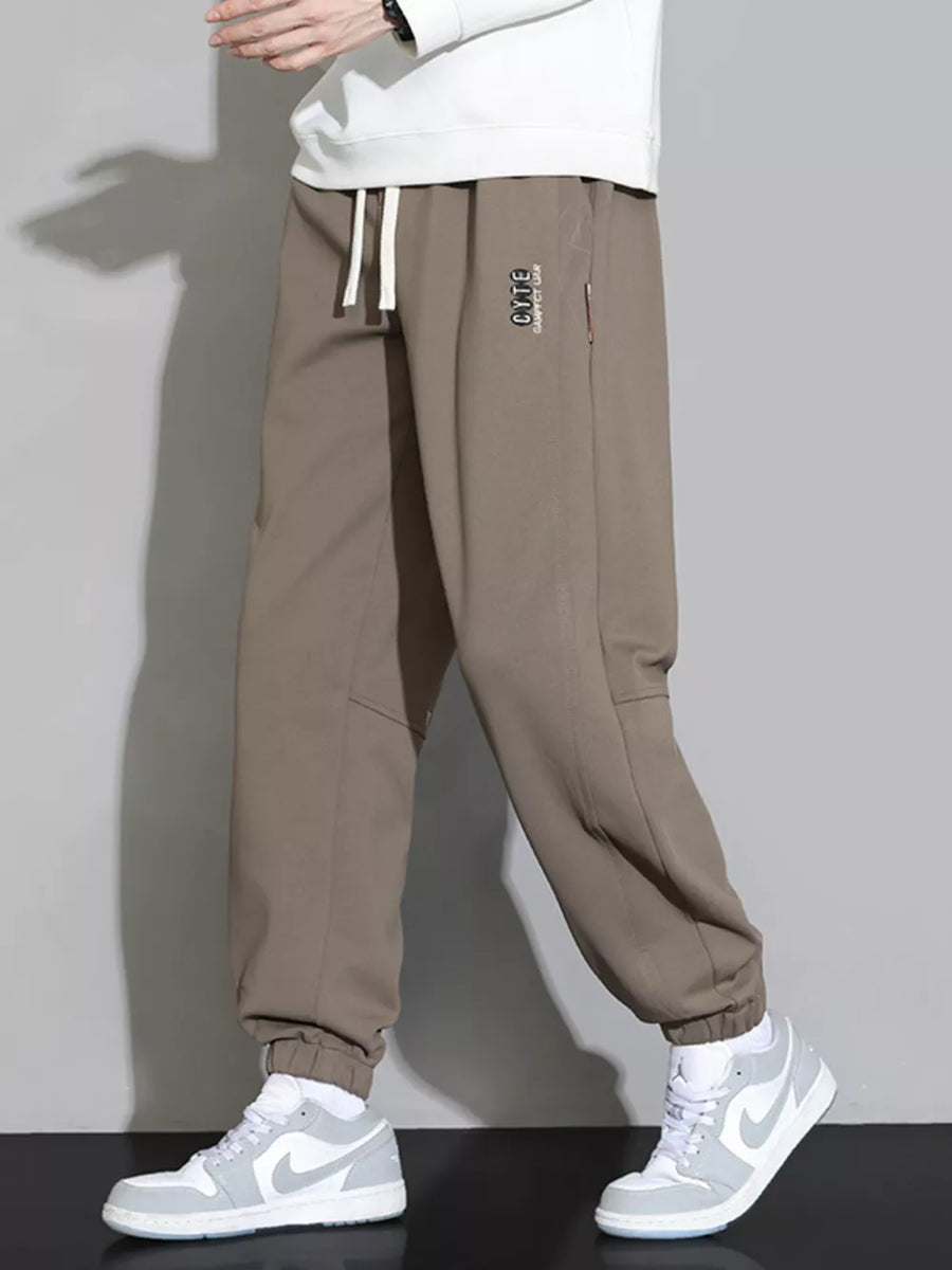 Brown cuffed ankle joggers with drawstring and subtle logo detail.