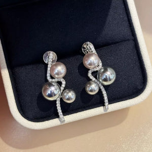Silver wave earrings with pearls and cubic zirconia accents.