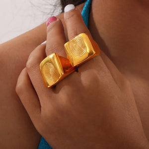 Gold sculpted fingerprint signet rings with square tops.