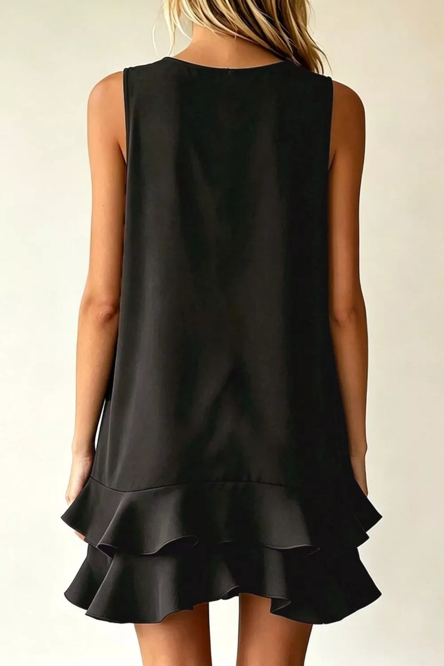 Black mini dress with V-neck, sleeveless, and tiered ruffle hem detail.