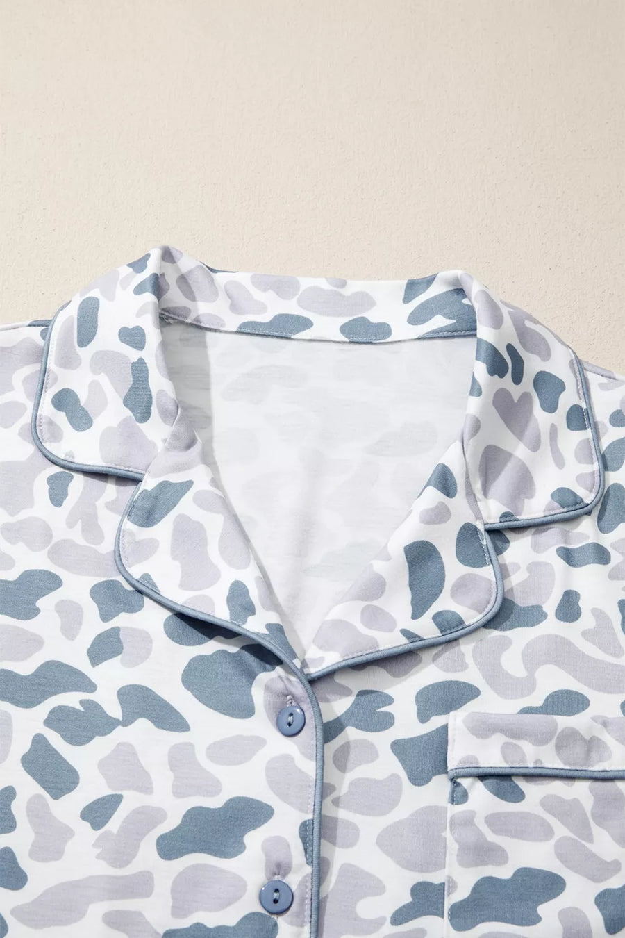Blue camouflage print button-down pajama top with piped trim and chest pocket.