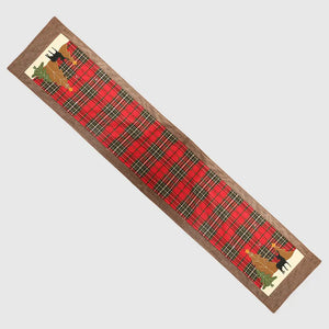 Festive red plaid table runner with appliqué Christmas trees and deer details.