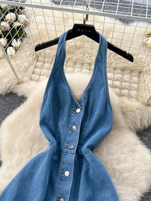 Blue denim V-neck halter dress with button placket and a-line skirt.
