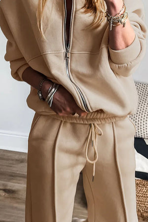 Tan seamed jogger set with zip-up jacket and drawstring pants.