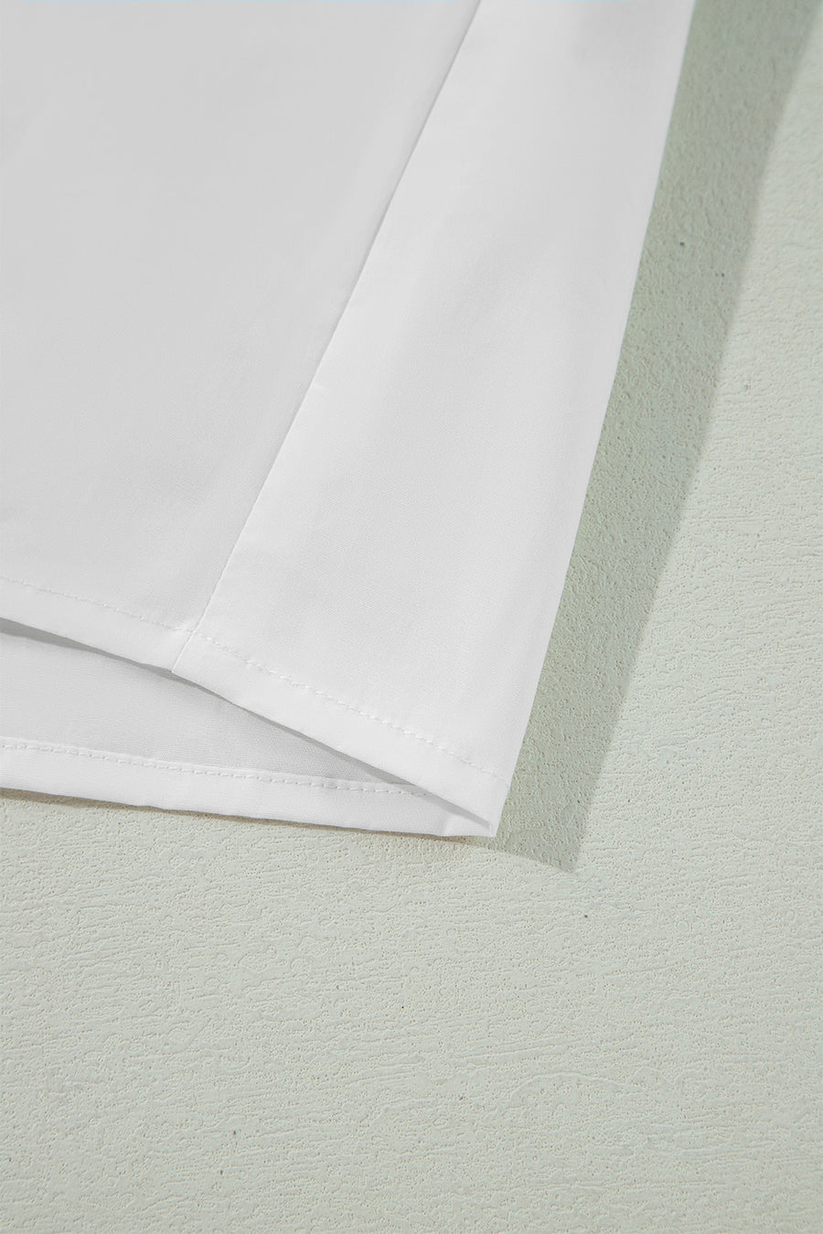 White piped trim bow blouse showing hem detail
