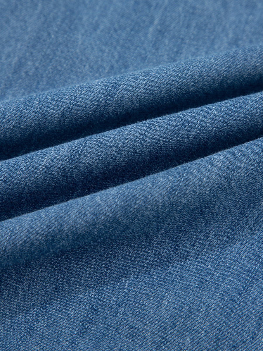 Blue denim fabric with visible texture and folds.