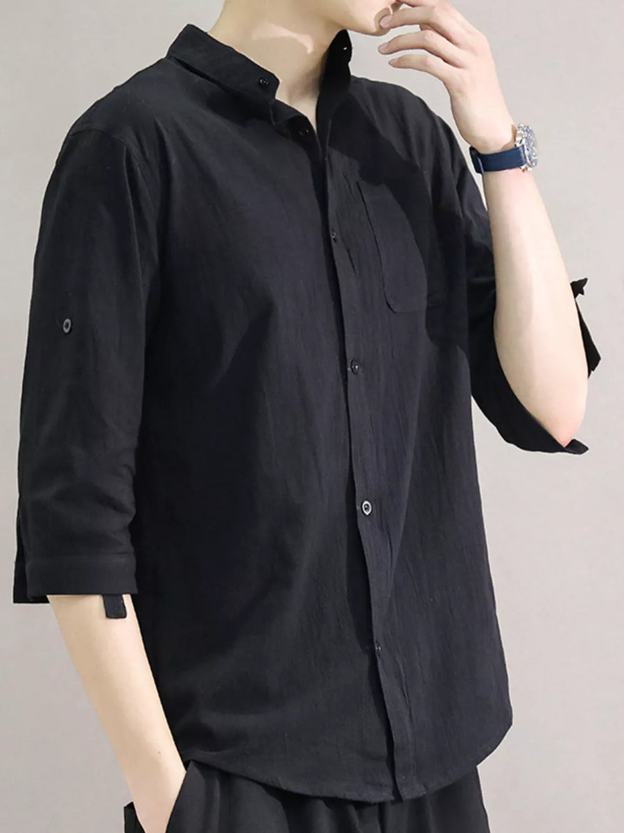Black cotton button-down shirt with roll-up sleeves and chest pocket.