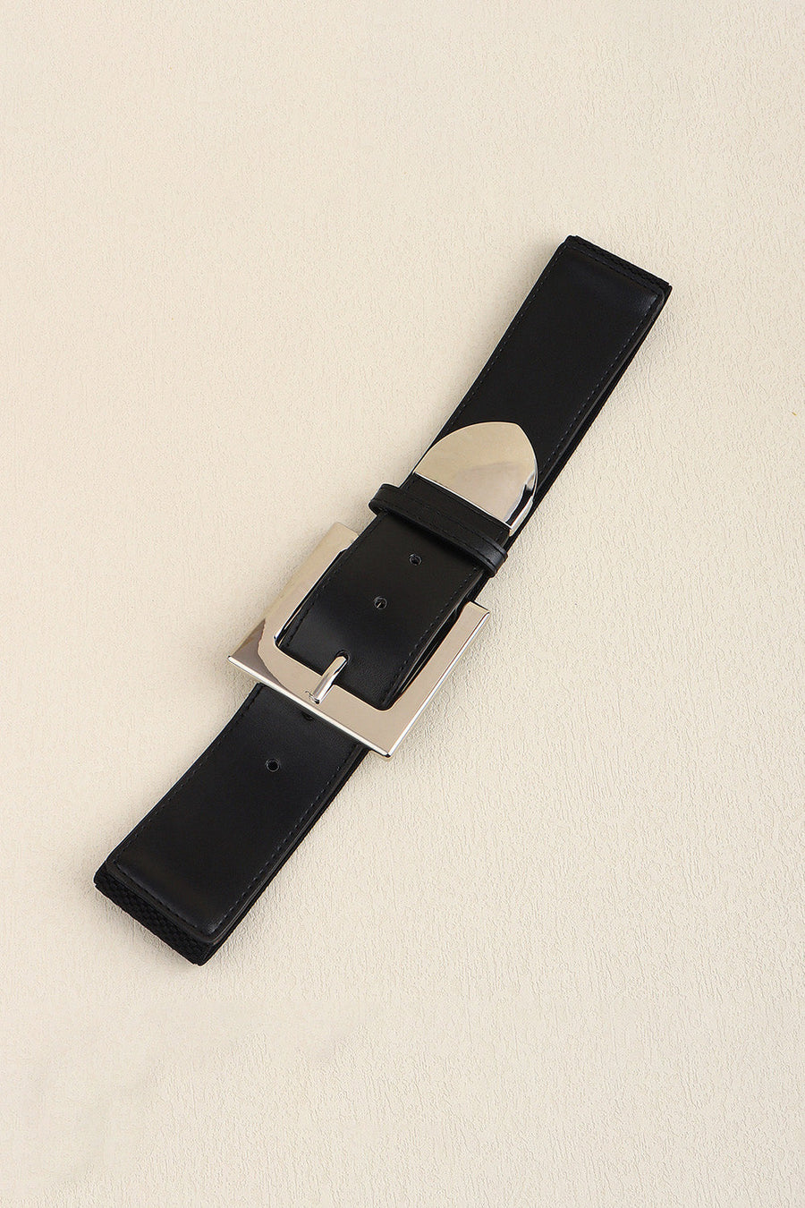 Black faux leather belt with a bold silver buckle and polished metal accents.