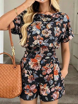 Floral two-piece set in navy blue with short sleeves and shorts, featuring pockets.