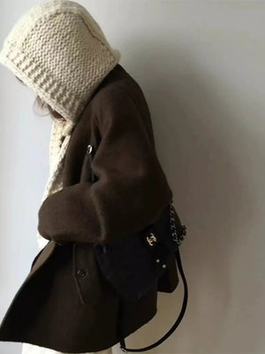 Off-white chunky knit wool earflap beanie hat with cozy texture.