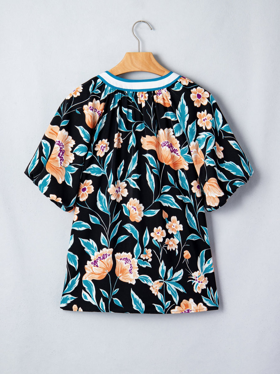 Black floral print blouse with bubble sleeves and a contrast neckline.