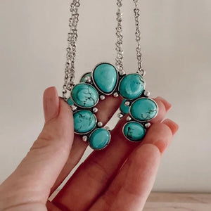 Turquoise horseshoe necklace with silver chain and alloy setting.