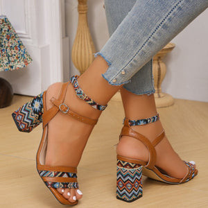 Open-toe block heel sandals with geometric pattern and ankle strap.