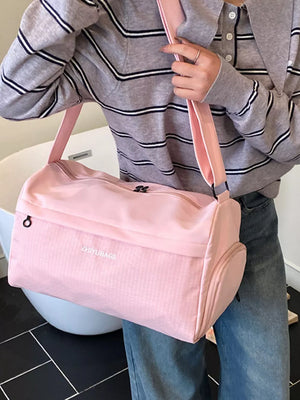 Pink travel organizer bag with textured panel and side pocket