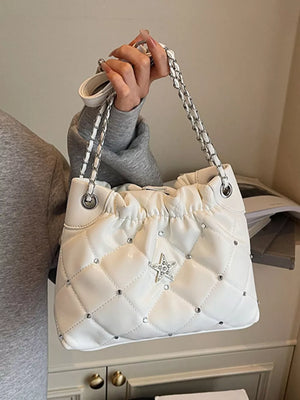 White quilted shoulder bag with diamond pattern, rhinestone star detail, and chain strap.