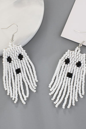 White beaded ghost fringe earrings with black bead faces and silver hooks.