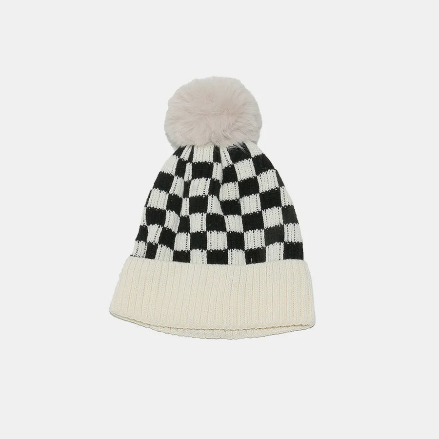 Checkerboard knit beanie with ivory ribbed cuff and faux fur pom.