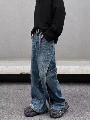 Men's washed wide-leg jeans in blue denim with distressed details and diagonal seams.