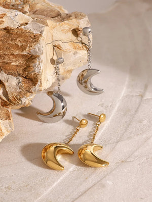 Gold and silver celestial crescent drop earrings with chain detail.