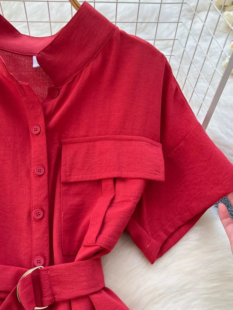 Red belted wide leg romper with button-down front, short sleeves, and chest pocket detail.