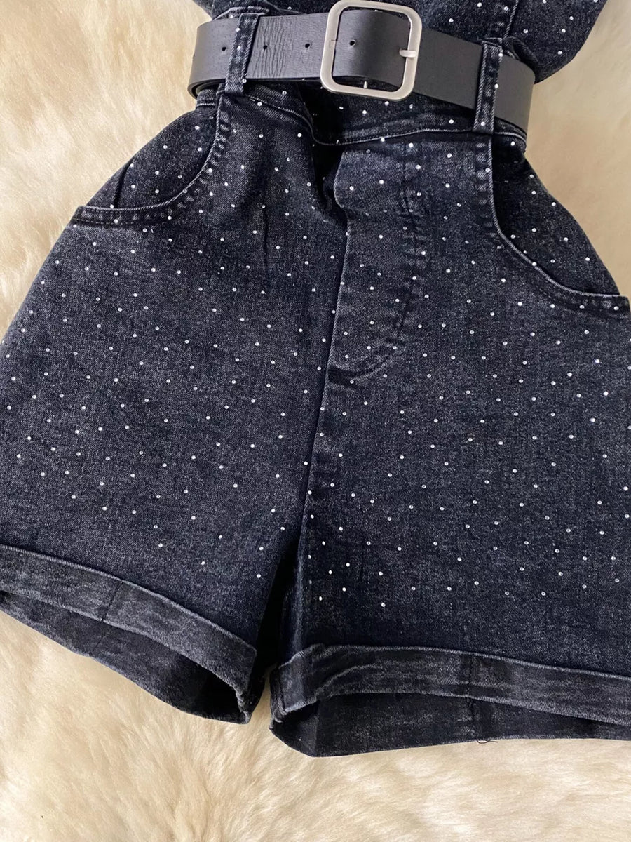 Black denim romper with rhinestone embellishments and a belted waist.