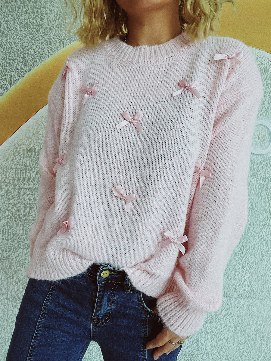 Blush pink knit crewneck sweater with allover satin bow embellishments.