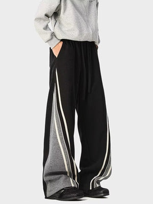 Men's black drawstring joggers with gray side panels and white stripes.