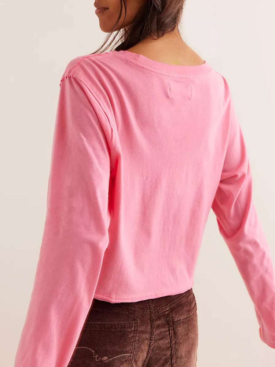 Pink long sleeve crop top with raw hem and crew neck.