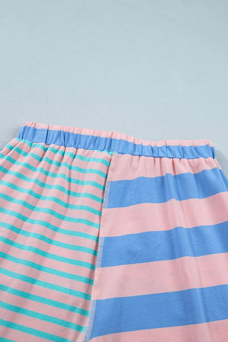 Striped shorts with pink, blue, and teal horizontal stripes and an elastic waistband.