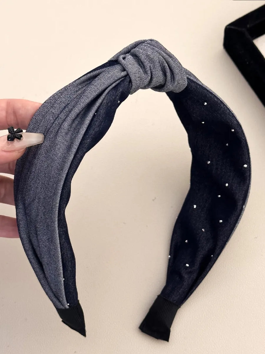Denim knot headband with crystal detail in dark gray, featuring a knotted front and scattered rhinestones.
