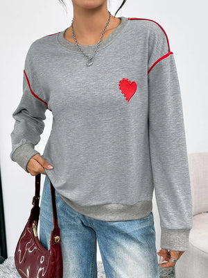 Gray sweatshirt with red heart embroidery and contrast piping detail.