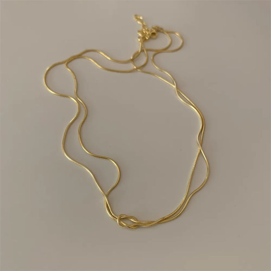 Gold snake chain necklace with a knot detail
