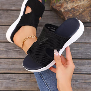 Black open-toe mesh sandals with white soles and a comfortable, breathable design.