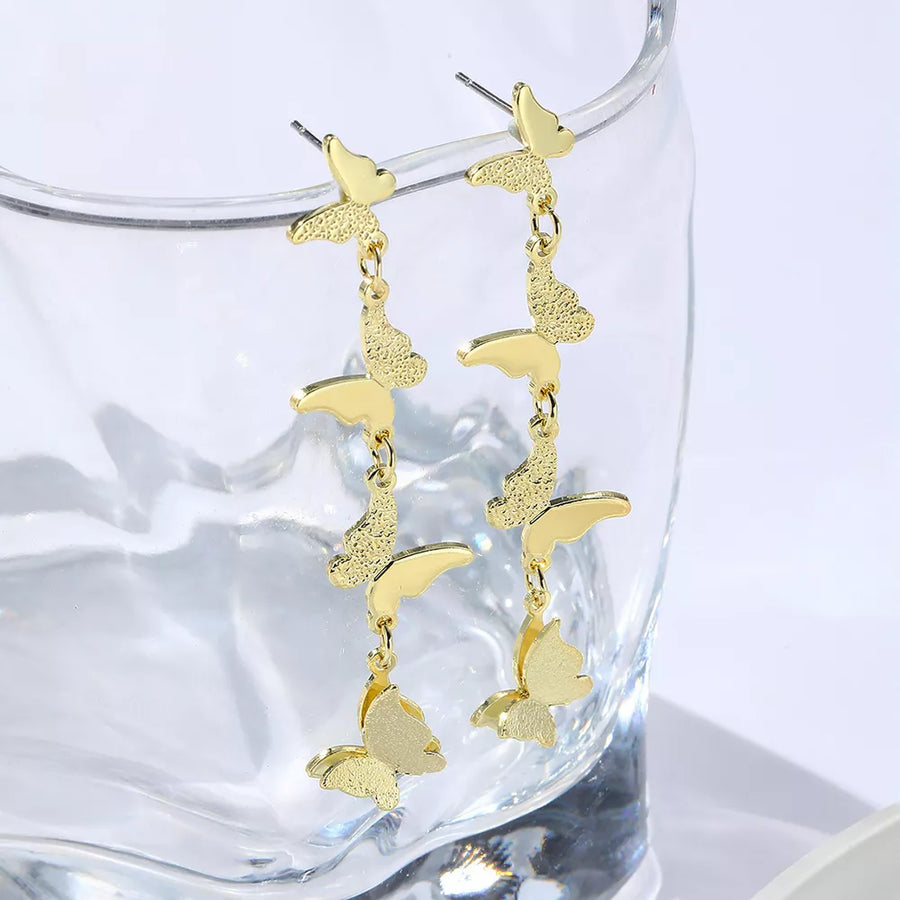 Gold earrings featuring dangling and butterfly