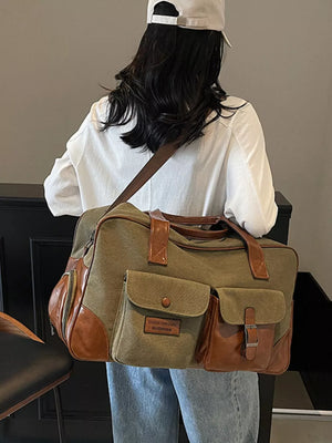 Green canvas travel bag with leather accents and multiple pockets