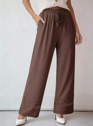 Brown wide-leg maternity pants with drawstring and lace trim detail.